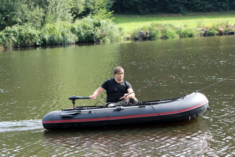 man fishing on an inflatable boat with a trolling motor