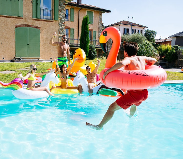 group of friends having fun with pool inflatables
