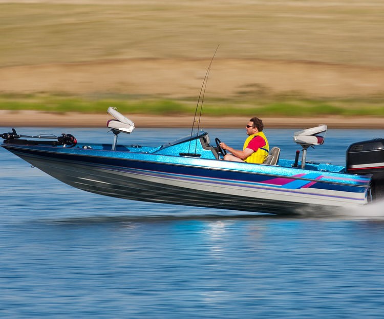 man riding boat with outboard motor at high speed