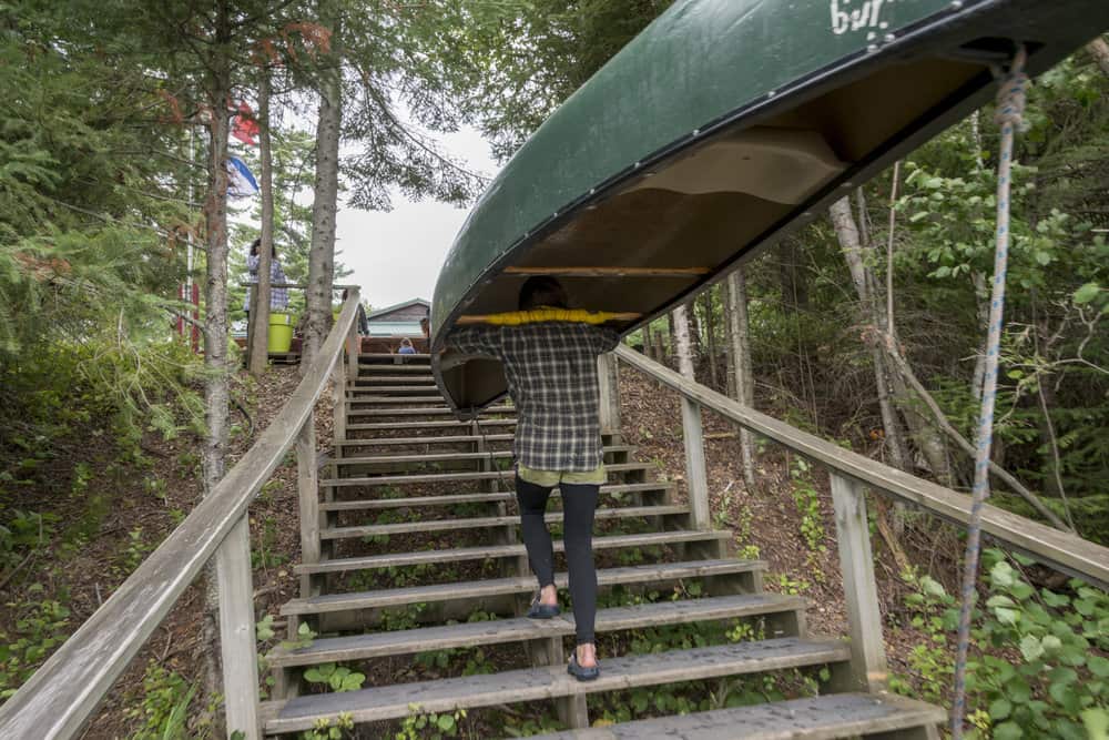 Teenage girl carrying a canoe on her head