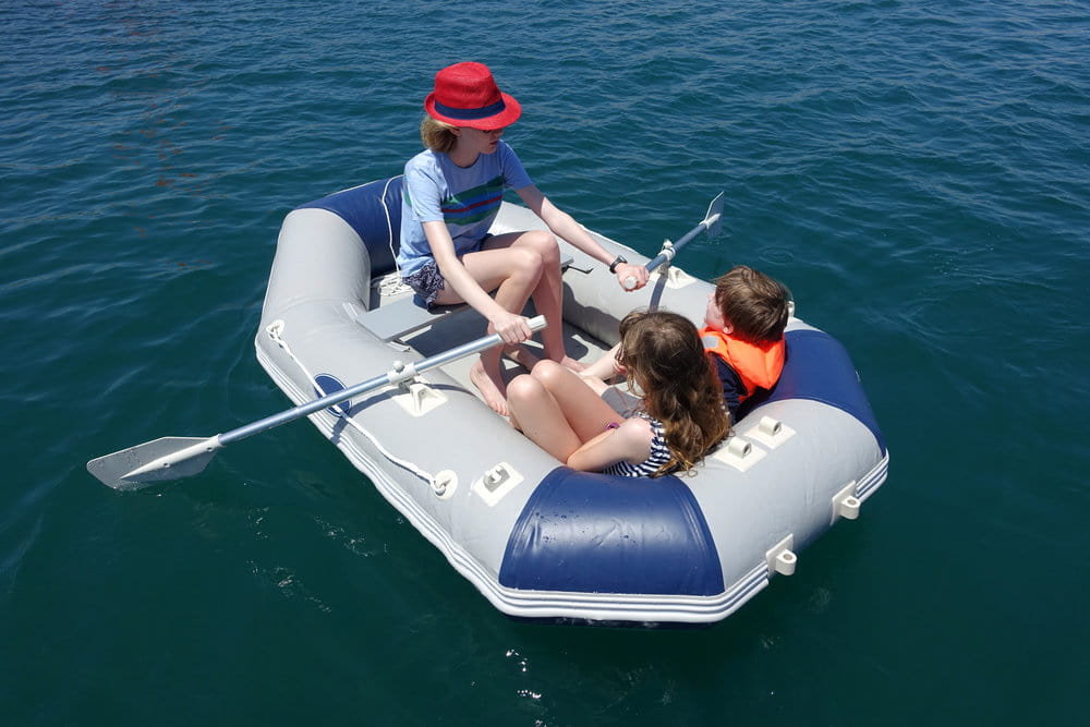 Three children having fun in an inflatable boat