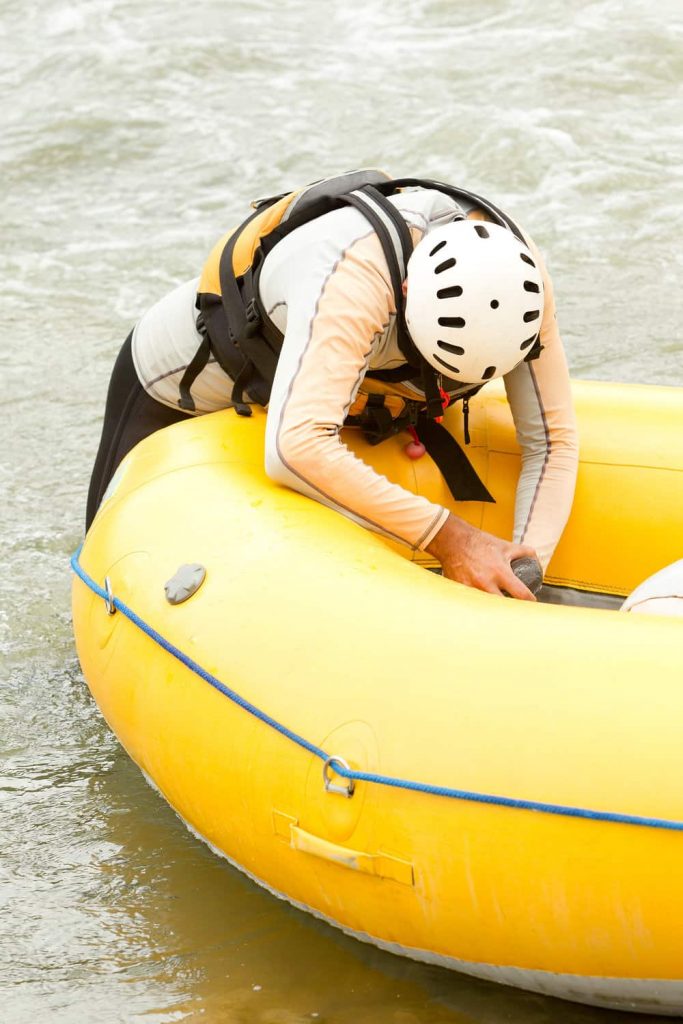 a man repairing his inflatable boat