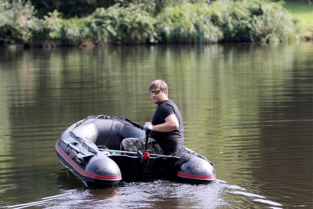 a young man going fishing on an inflatable boat with trolling motor