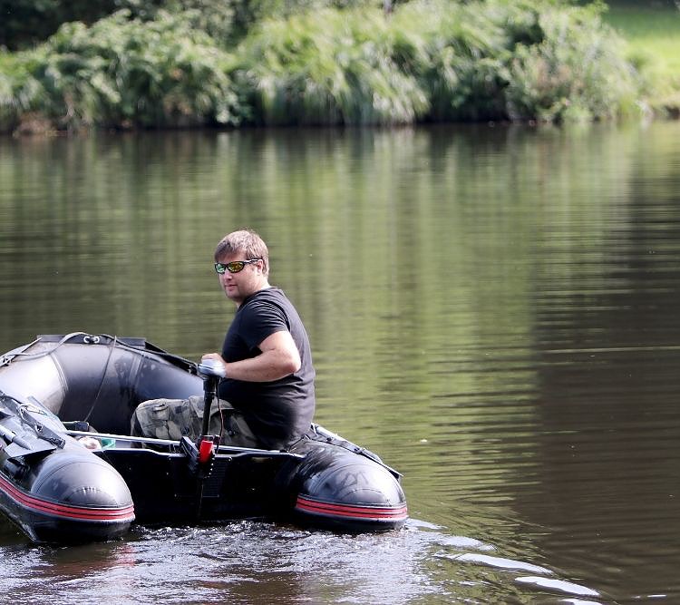 An Inflatable Boat going upstream with a trolling motor