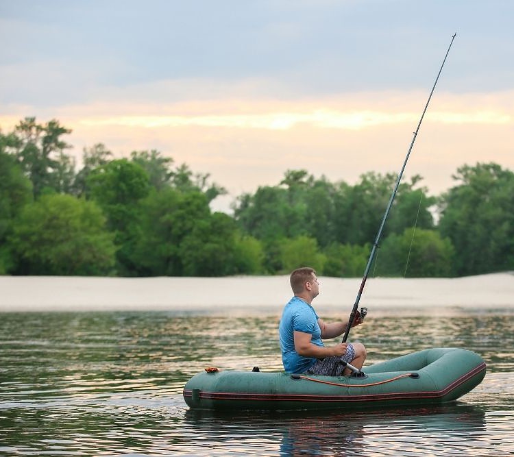 a man fish quietly with an inflatable boat