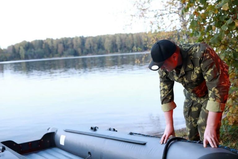 man checking leaks in an inflatable boat