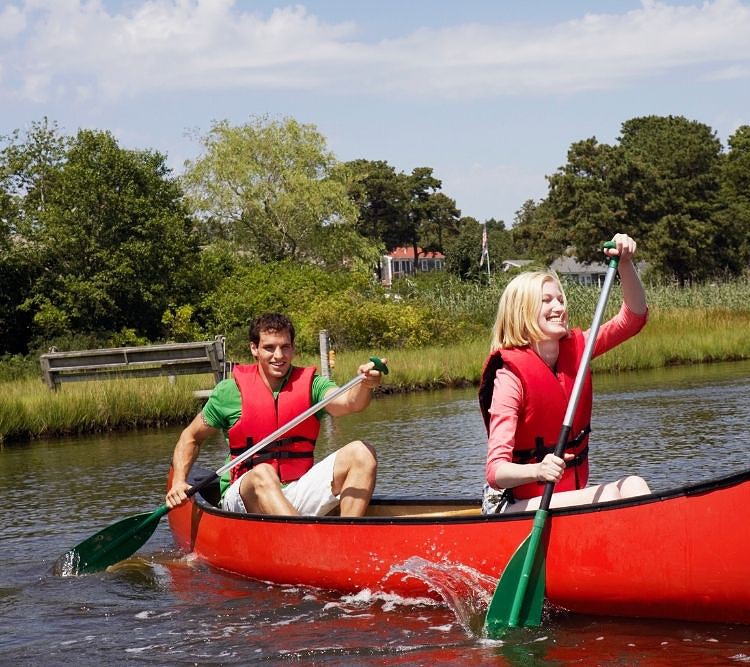 a couple paddling on a red canoe