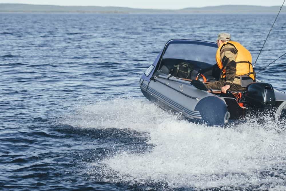 man driving fast in inflatable boat on the ocean