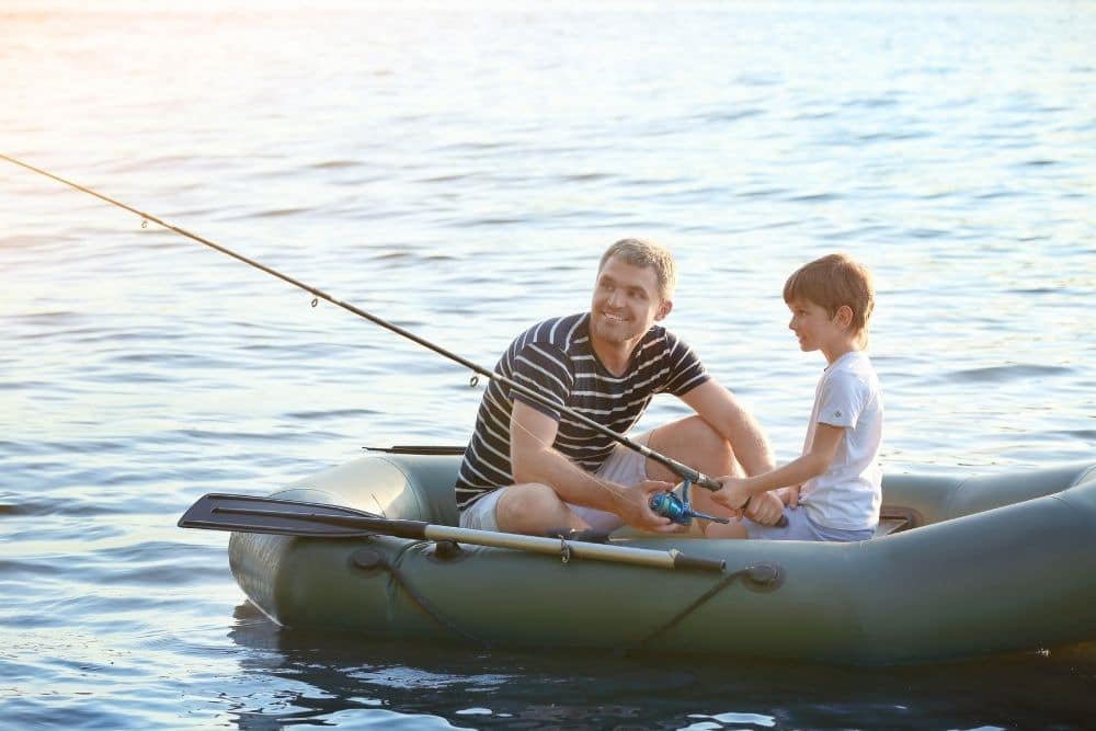 father and son going fishing on a green inflatable boat