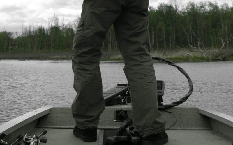 an angler is on his boat running by a trolling motor with foot pedal and fish finder