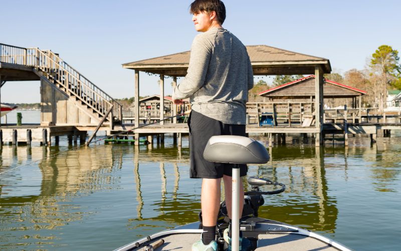 man standing and fishing on his boat that runs with a Min Kota trolling motor