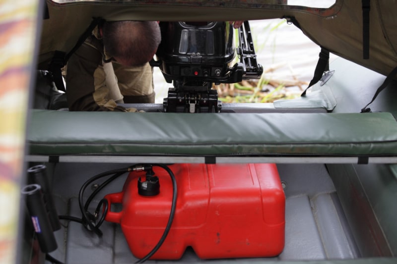 Checking the fuel problem of an outboard motor and red plastic boat fuel tank