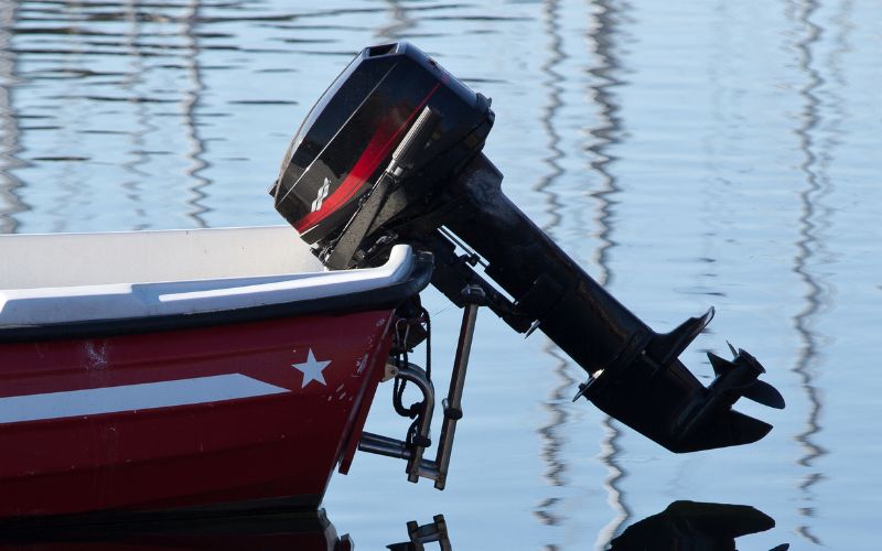 boat with a perfectly mounted outboard motor is anchoring in a lake