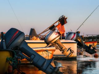 outboard motors on boats in sunset