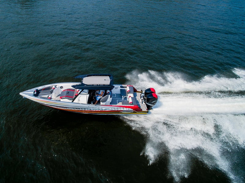 a man driving a boat with 2 outboard motors