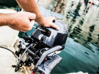 man starts the outboard boat engine