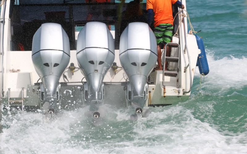 Boat outboard motors running fast with water splashing